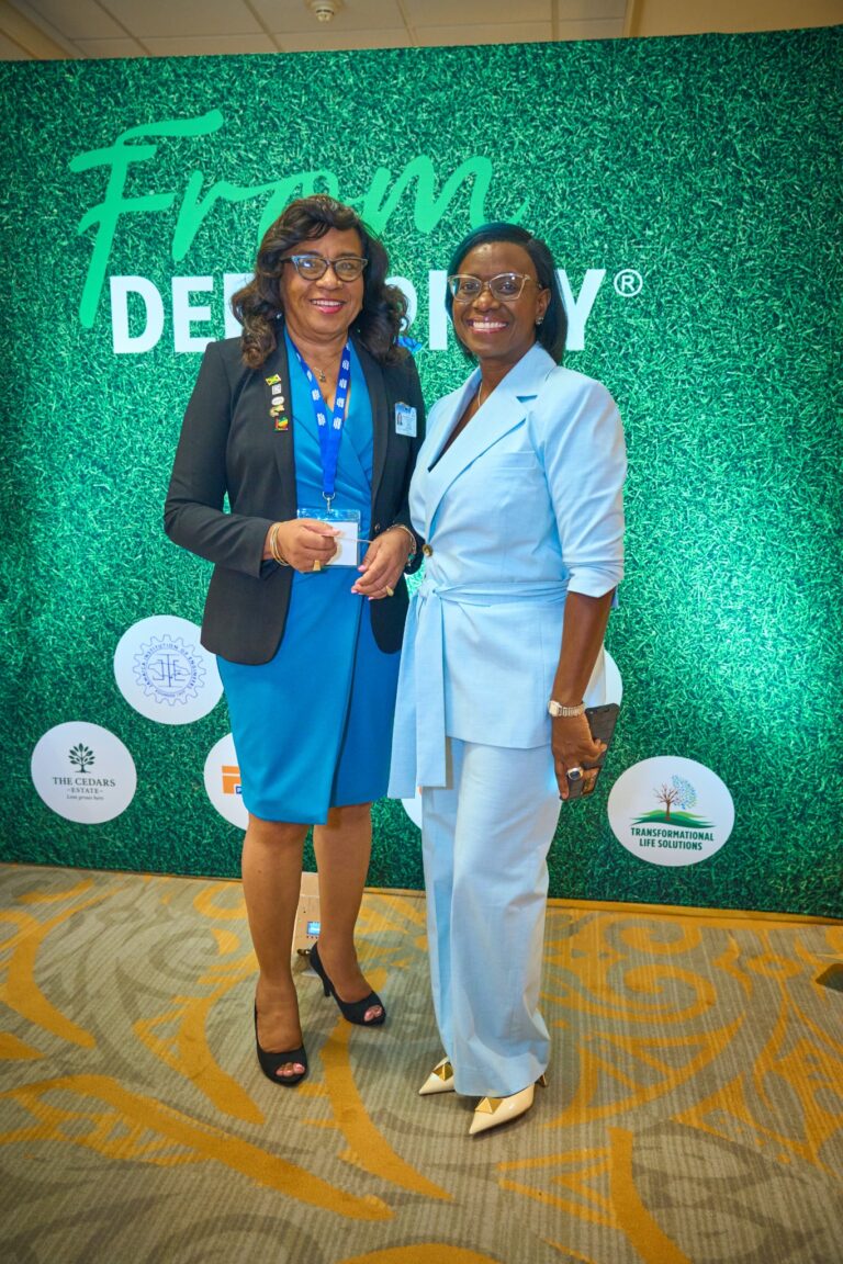 Two guests at the From Deed to Key backdrop